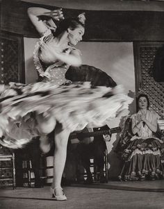 an old photo of a woman dancing with her legs spread out in front of her