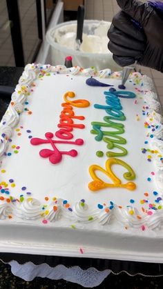 a birthday cake with white frosting and colorful letters on it that says happy birthday