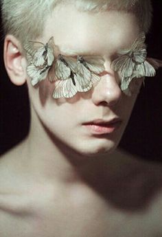 a woman with white butterflies on her face