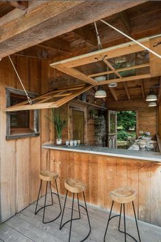 two stools are sitting in front of the bar on the outside of a cabin