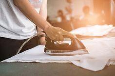 a person ironing fabric on an ironing board