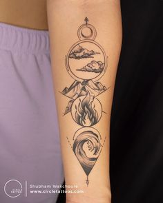 a person with a tattoo on their arm that has three different things in it, including mountains and clouds