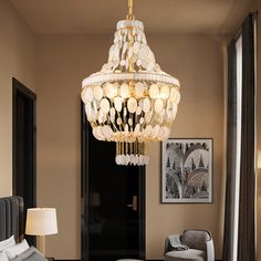 a chandelier hanging from the ceiling in a room with a bed and chair