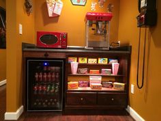 a coffee machine and some snacks in a small room with an orange wall behind it