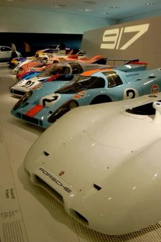 a bunch of cars are on display in a museum