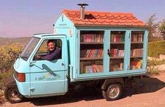 a man sitting in the back of a truck with a book case on it's side