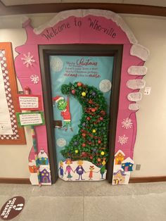 a door decorated with christmas decorations in the shape of a tree and people on it