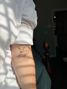 a person with a small tattoo on their left arm and the outline of a sheep