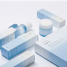 an assortment of skin care products displayed on a white surface with blue and gray boxes