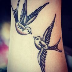 a couple of birds that are on the side of a woman's leg and arm