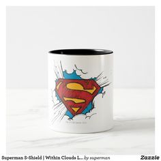 a white and black coffee mug with a superman logo on the front, in color