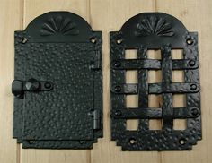 two black iron door handles on a wooden surface