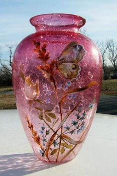 a pink vase sitting on top of a white table