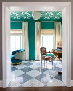 an open door leading to a living room with blue walls and checkered flooring