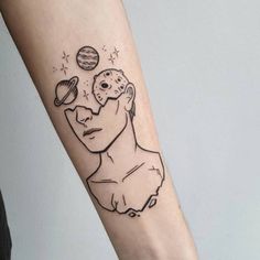 a person with a tattoo on their arm that has an image of a man's face and planets