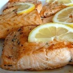 salmon with lemon slices on a white plate