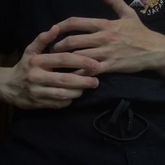 two hands on top of each other in front of a person's chest and arm