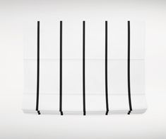 black and white vertical blinds hanging from the ceiling in front of a wall with horizontal lines on it