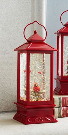 two red lanterns sitting next to each other on top of a book shelf with books