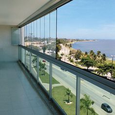 an empty room with a view of the ocean and palm trees on the other side