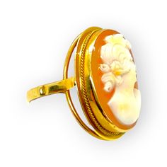 From Italy, this fascinating cameo ring features an oval shell cameo carved to depict the dreamy profile of a young woman who adores flowers. Set in polished 18KT yellow gold frame. Original price $1,400. The cameo is 23x19mm and weighs 4.1 grams. This ring is size 6. Luxury Elegant Cameo Ring, Gold Cameo Ring Jewelry, Luxury Gold Cameo Ring, Collectible 14k Gold Cameo Rings, Antique Cameo Yellow Gold Ring, Baby Necklace, Portrait Of A Woman, Shell Ring, Cameo Ring