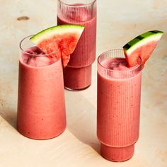 three glasses filled with watermelon and cucumber on top of a table