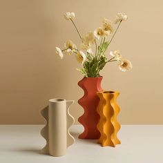 two vases with flowers in them sitting on a table