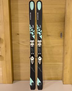 a pair of skis sitting on top of a counter next to a door with wood paneling