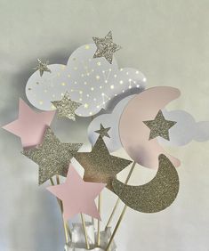 a vase filled with paper stars and moon cutouts