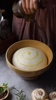 a person pouring something into a wooden bowl