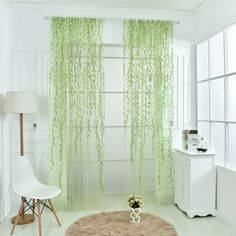 a living room with white furniture and green curtains