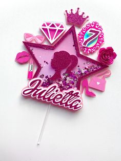 a pink cake topper with the word fabulous on it and some decorations around it