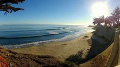 the sun is shining over the beach and ocean