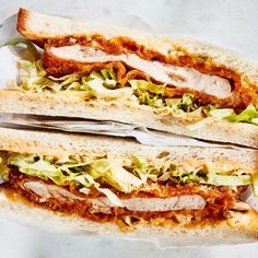 two sandwiches with meat, lettuce and tomato sauce