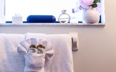 a towel hanging on the wall next to a vase with flowers and other bathroom items