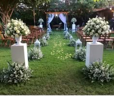 an outdoor ceremony set up with white flowers and greenery