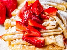 pancakes with powdered sugar and strawberries on top