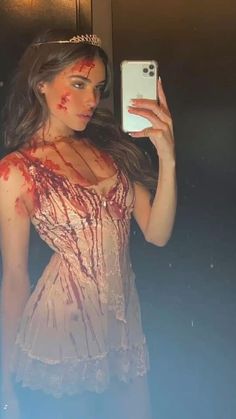 a woman with blood all over her body is taking a selfie