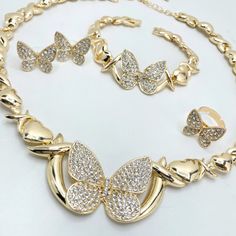 18k Gold Filled Cubic Zirconia Butterfly with XoXo Hug and Kisses Link Shape Set, 04 Pieces, Wholesale Jewelry Making Supplies. - Necklace, Bracelet, Earrings and Ring. - Set Size:Necklace Thickness: 11mm | Bracelet Thickness: 11mm | Necklace Length: 18'' to 20'' with 2 inch extender | Bracelet Length: 8 inches | Necklace Butterfly Width: 25mm | Bracelet Butterfly Width: 35mm | Adjustable Ring Size: 8 | Earrings: Height: 18mm | Earrings Width: 18mm Valentine's Day Gold Jewelry With Sparkling Stones, Valentine's Day Gold Rhinestone Jewelry, Gold Cubic Zirconia Jewelry Sets With Clavicle Chain, Luxury Gold Crystal Jewelry Sets, Gold Cubic Zirconia Jewelry Set For Valentine's Day, Gold Rhinestone Jewelry Sets For Anniversary, Gold Jewelry Sets With Rhinestones As Gifts, Gold Jewelry Sets With Diamond Accents And Crystal, Gold Jewelry Sets With Diamond Accents For Parties