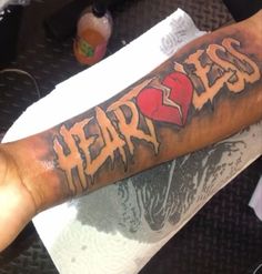 a man with a tattoo on his arm that says fear and an image of a heart