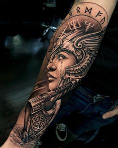 a person with a tattoo on their arm holding a knife and wearing a headdress