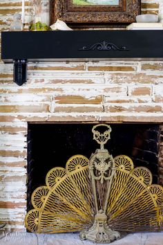 a fireplace with a painting on top of it and a fan in front of it