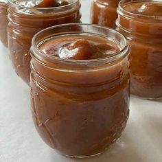 four jars filled with caramel sauce sitting on top of a table