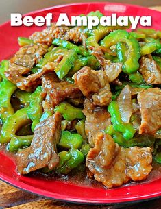 beef and peppers in sauce on a red plate with the words beef ampalaya