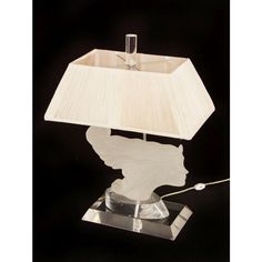 a table lamp with a white shade on it's base and a silver spoon