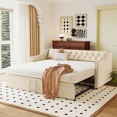 a white bed sitting on top of a hard wood floor next to a wooden dresser