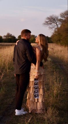 Pregnancy announcement photo in field, woman in gold dress outfit, aesthetic pregnancy announcement with sonogram Couple Baby Announcement Photo Shoot, Annoucment Pictures Aesthetic, Christmas Tree Farm Pregnancy Reveal, Announcement Pictures Pregnancy, Pregnancy Announcement Couple Photos, Fall Baby Announcement Photoshoot, Baby Accouncement, Fall Pregnancy Announcement Photoshoot, Pregnancy Announcement Poses