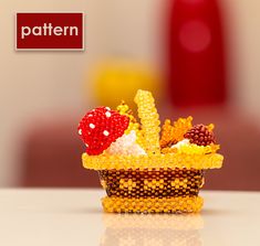 a basket filled with fruit and vegetables on top of a white table next to a red vase