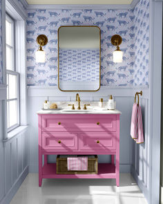 a bathroom with pink vanity and blue wallpaper