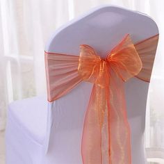 an orange bow on the back of a white chair